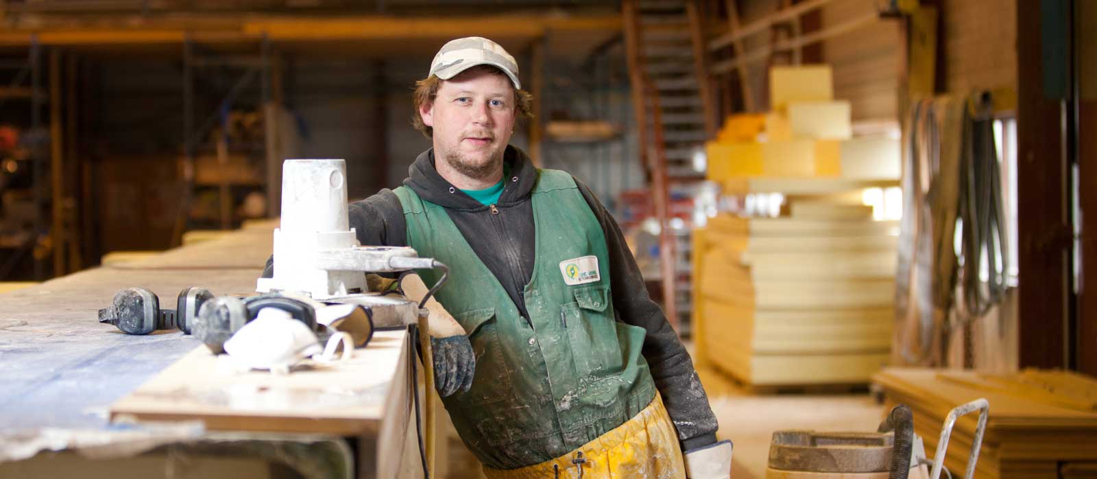 Houtbewerker poseert bij een werkbank
