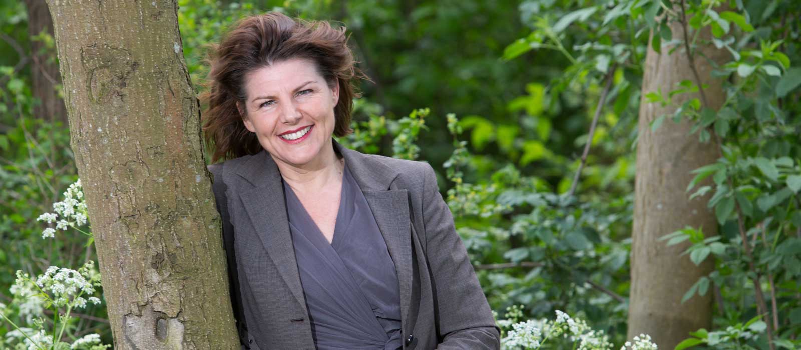 Zakelijk portret van een vrouw buiten in een groene tuin